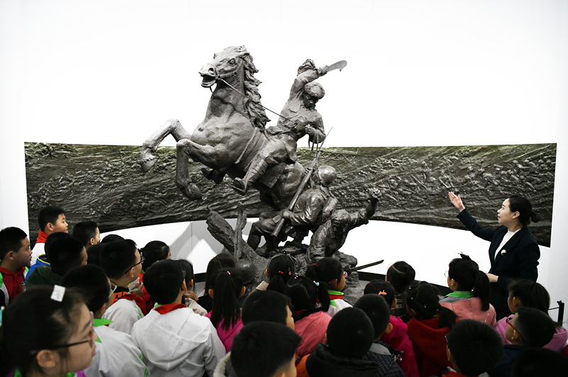 2019年4月4日，在東北烈士紀(jì)念館，學(xué)生們?cè)诼?tīng)講解員講解。